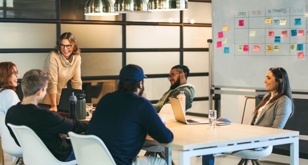 Successful teamwork in a diverse office: Colleagues smiling and talking in a productive meeting